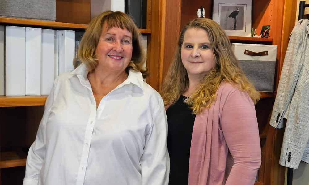 Margaret Doyle Fitzpatrick, Lawyer and Heidi Barrett, Paralegal standing in front of a bookshelf.